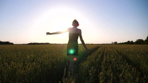 Happy Punk Woman with Tattoos Jogging Through Green Barley Field at Sunset Carefree Hippie Girl in