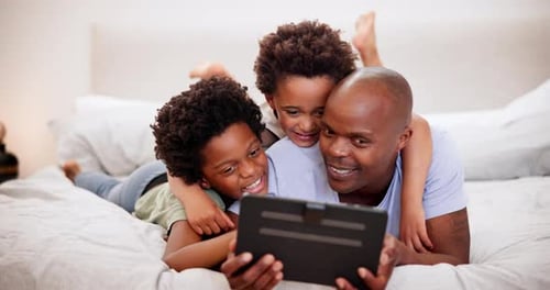 Father and Sons Watching Tablet on Bed