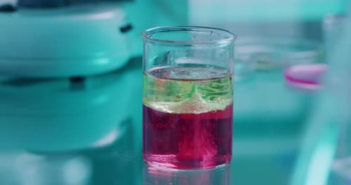 Test tube with bright toxic liquid foaming under an oil base to prevent volatile reaction