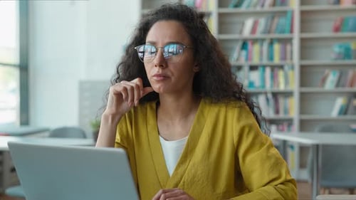 Une femme hispanique latina travaille à taper sur un ordinateur portable dans une bibliothèque universitaire