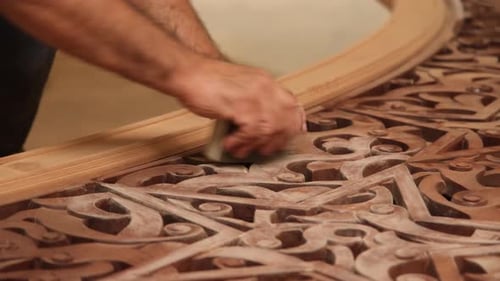 Artisan Hand Sanding Intricate Wood Carving Design