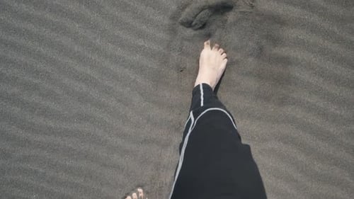 Slow motion barefoot walking in the sand.