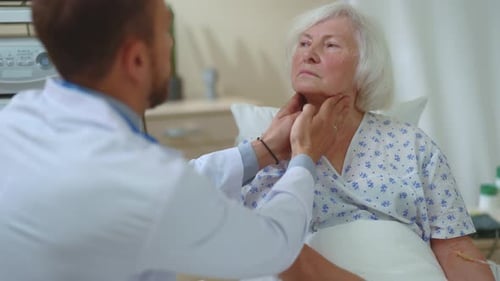 Doctor Examines Senior Woman in Hospital Bed