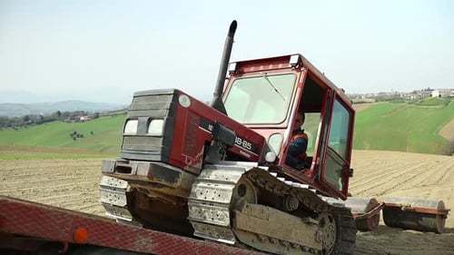 Ladevorgänge eines Raupentraktors auf einem landwirtschaftlichen Kipper in einem abgelegenen italienischen Land
