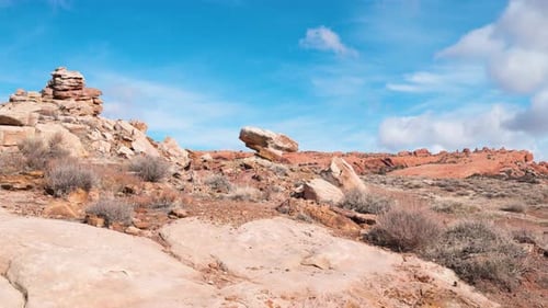 Static shot of a Large Boulder perched on the mountains of Arches National Park with a vivid blue sk