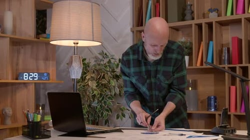 Middle Aged Interior Designer Creating Architectural Project and Drawing Sketch