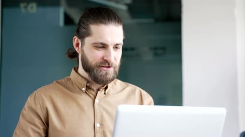 Young Adult Man Waving in Video Conference