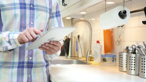 Man Using Tablet in Bright Kitchen