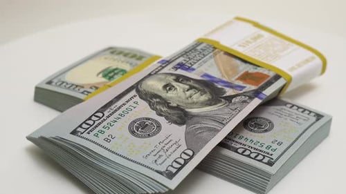 Stack of Bank Bundles with US Dollars on a White Background Closeup Shot of New Freshly Printed