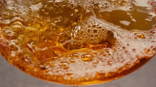 Orange or White Wine Bottle and Glass Against a Sunset in a Peaceful Vineyard Pouring of Ecological