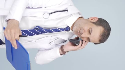 Doctor Talking on Phone Holding Clipboard