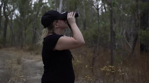 Woman Observes Forest With Binoculars