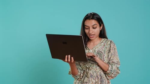 Женщина, составляющая письмо, тщательно печатает на клавиатуре ноутбука