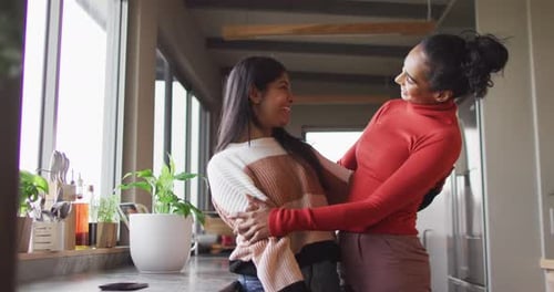 Video of happy biracial female friends embracing