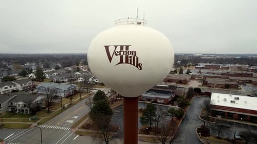 gros plan aérien de Vernon Hills, logo de l'Illinois sur un château d'eau, volant et révélant la ville