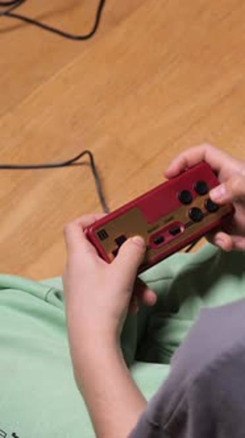 Person Holding a Small Retro Game Console