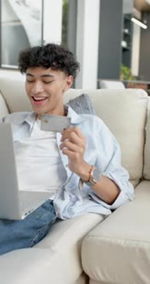 Young Adult Shopping Online with Laptop and Credit Card