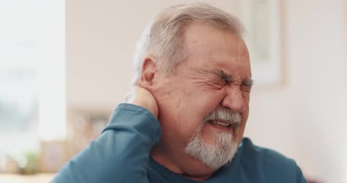 Man with neck pain in a home setting