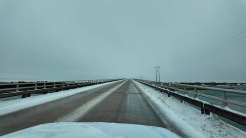 Driving over a snow covered bridge in the winter.