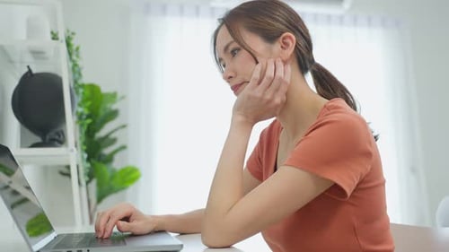 Woman Works at Home on Laptop Computer