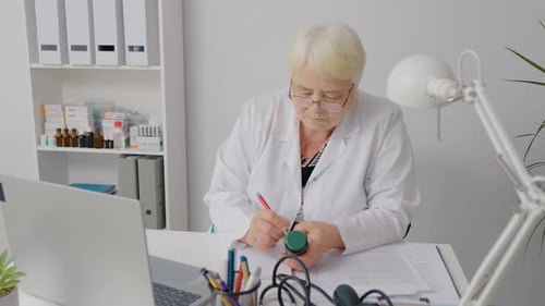 Doctor Writes Prescription in Bright Medical Office