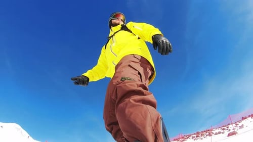 Ansicht eines jungen Mannes, der Snowboard fährt von unten