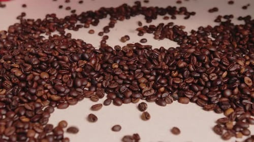 Coffee beans fall onto the table. a bunch of coffee beans. coffee pours onto the table. roasted coff