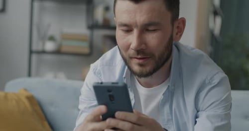 Man Using Smartphone While Sitting on Couch