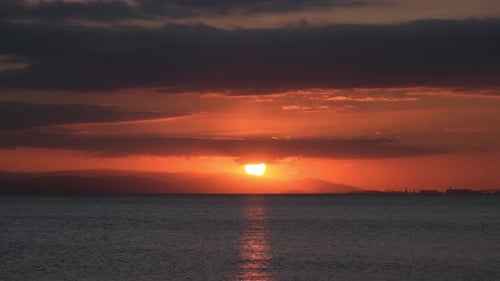 Fiery Sunset Over Calm Ocean Water