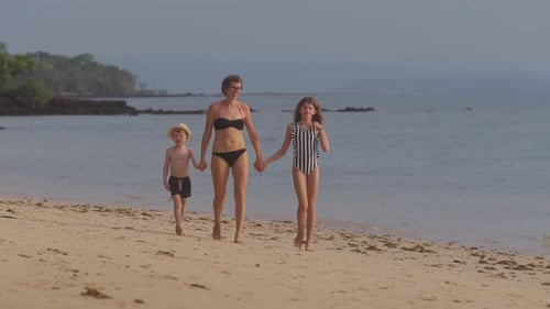 Mom With Her Children Walking On The Seashore