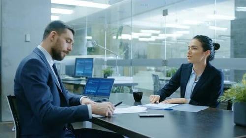 Business Meeting Concludes with Handshake in Modern Office