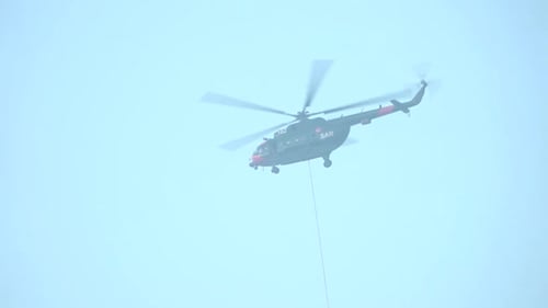 Der
Hubschrauber fliegt, um den Wassertank zu füllen und das Feuer zu löschen. Filmmusik verschwommene Umgebung.
Ein