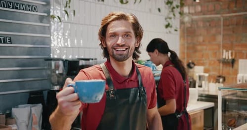 Smiling man holding coffee cup in cafe