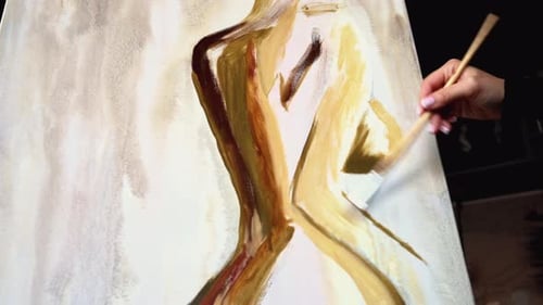 Beautiful woman painting with watercolors at an art gallery workshop