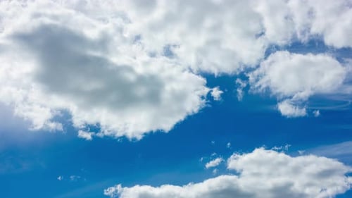 Blue Sky with White Clouds and Sun. Puffy Fluffy White Clouds Moving Fast. Cumulus Cloudscape