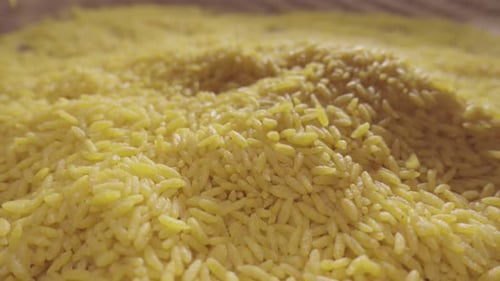 Golden Rice or Pasta Grains Being Sprinkled
