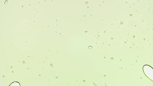 Transparent Green Cosmetic Gel Fluid With Molecule Bubbles and Oil on White Background Macro Shot