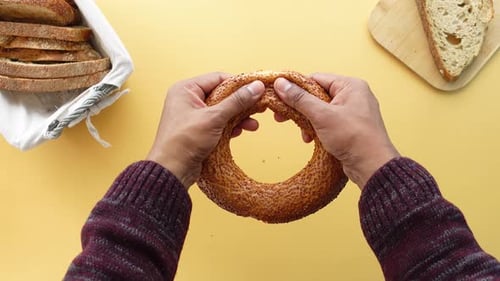 Blick von oben auf das Handknacken eines türkischen Bagel Simit