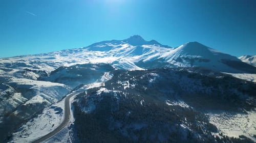 Snowy Mountains and Winding Road Aerial View