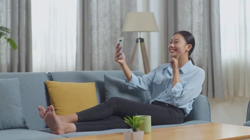 Smiling Woman Video Chatting on Smartphone in Living Room