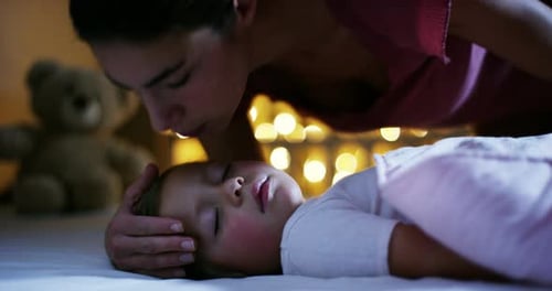 Mother Kisses Sleeping Child at Bedtime