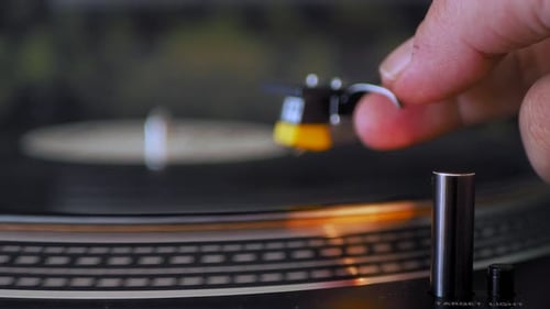 Extreme close up side view of a vinyl record turntable. Included tone arm, cartridge, stylus, needle