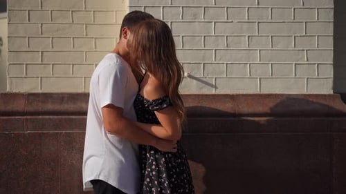 Loving Hugging Couple Kissing in Slow Motion Standing on City Street Outdoors