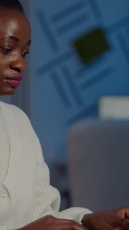African Bookkeeper Working Overtime Calculating Profit