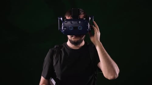 Man Wearing VR Headset Adjusts the Device