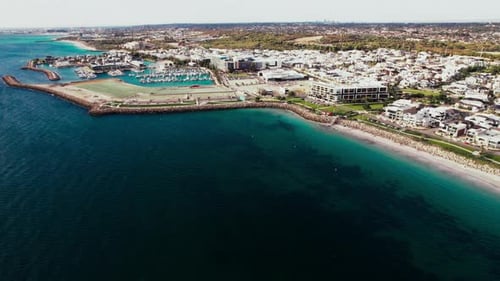 Beautiful aerial view of coastal area showcasing sandy beach and marina at midday