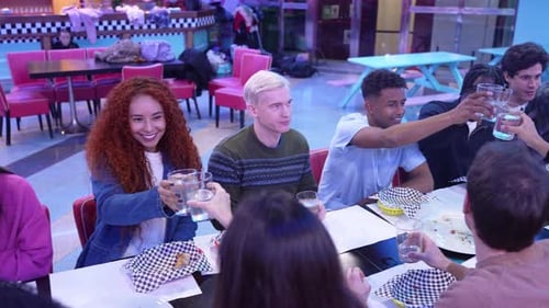 Friends Toasting Drinks at a Restaurant in Slow Motion