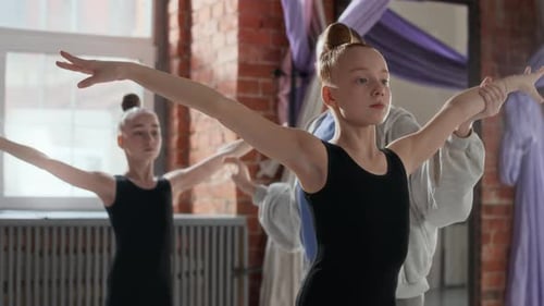 Young Instructor Supporting Chin of Fit Girl with Outstretched Arms