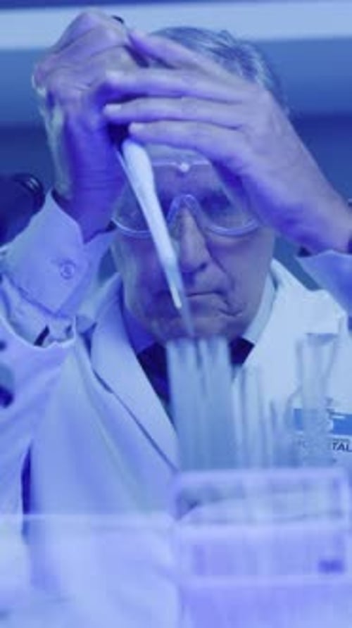 Man Using Pipette with Test Tubes in Lab