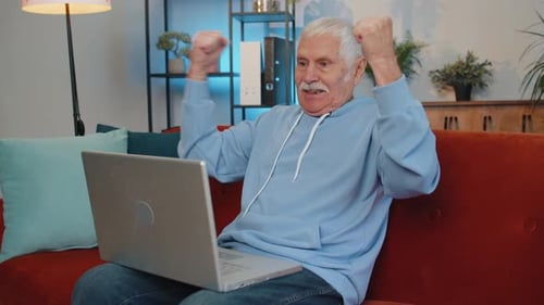 Overjoyed Senior Man Working on Laptop Celebrate Success Win Money in Lottery Get Online Good News